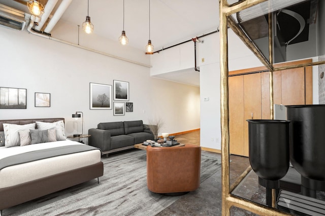 bedroom with a high ceiling and concrete floors