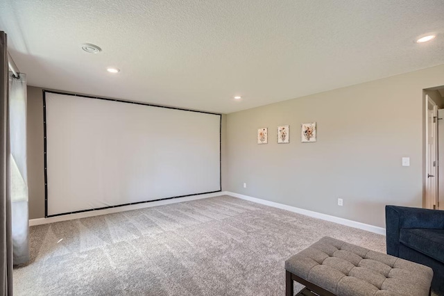 cinema room featuring light carpet and a textured ceiling