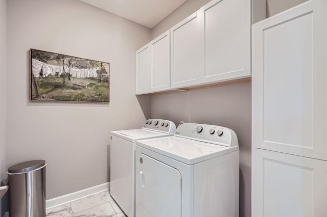 clothes washing area with cabinets and washer and clothes dryer