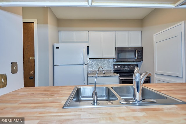 kitchen with sink, backsplash, white cabinetry, stainless steel electric stove, and white fridge