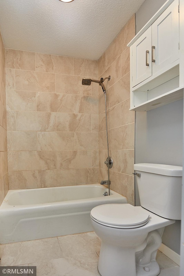 bathroom featuring a textured ceiling, tiled shower / bath combo, and toilet