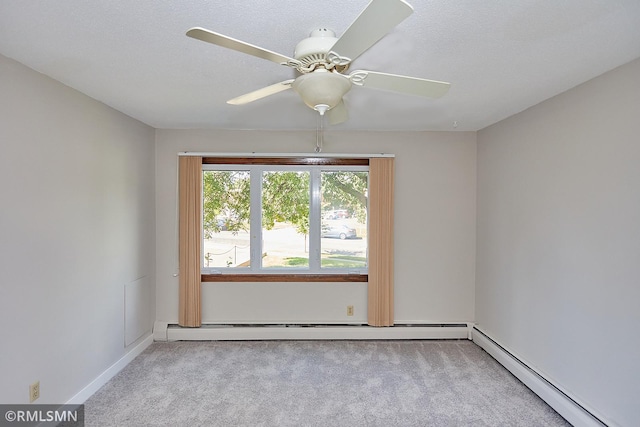 spare room with light colored carpet, ceiling fan, baseboard heating, and a textured ceiling