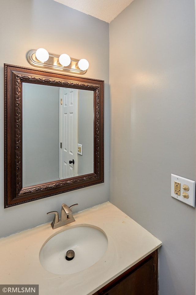 bathroom featuring a textured ceiling and vanity