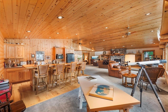 dining space with recessed lighting, a stone fireplace, wooden ceiling, ceiling fan, and vaulted ceiling