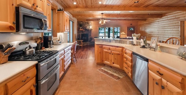 kitchen featuring beam ceiling, a sink, open floor plan, stainless steel appliances, and wooden ceiling