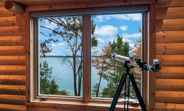 room details featuring wooden walls and a water view