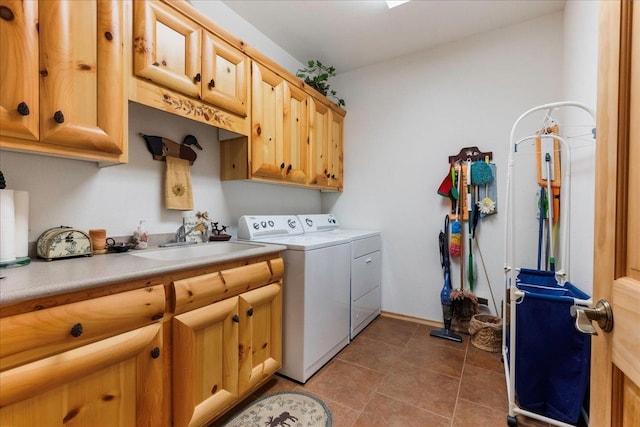 clothes washing area with washer and clothes dryer, cabinet space, tile patterned floors, and a sink