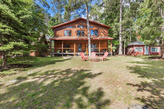 back of property featuring a yard and a fire pit