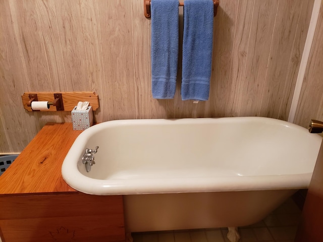 bathroom with wood walls and a bathtub