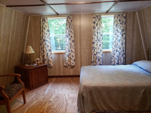 bedroom with wood walls and hardwood / wood-style flooring