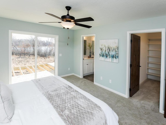 carpeted bedroom with multiple windows, a spacious closet, connected bathroom, and ceiling fan