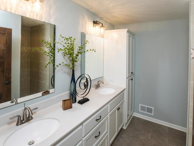 bathroom featuring a textured ceiling and vanity