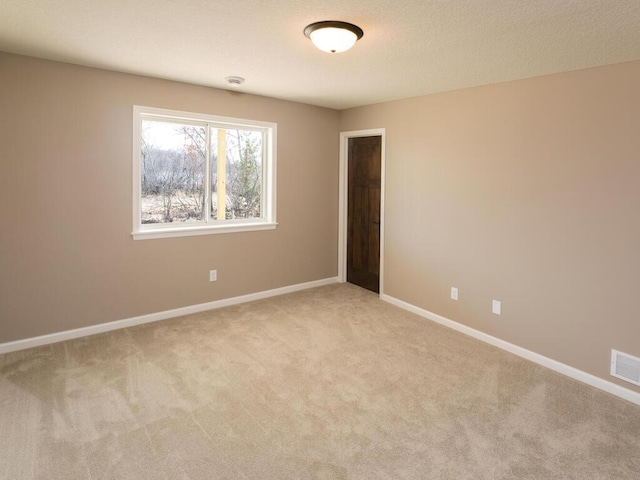 carpeted spare room featuring a textured ceiling