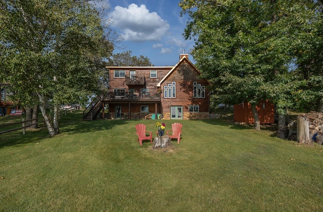 back of property with a storage shed, a deck, and a lawn