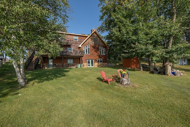 back of property featuring a wooden deck and a yard