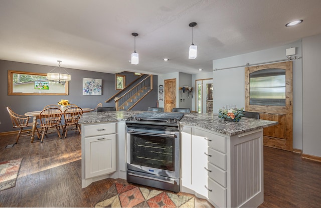 kitchen featuring hanging light fixtures, stainless steel range with electric stovetop, dark hardwood / wood-style floors, and white cabinetry