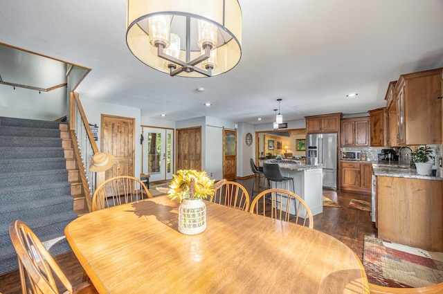 dining area with dark hardwood / wood-style flooring and a notable chandelier