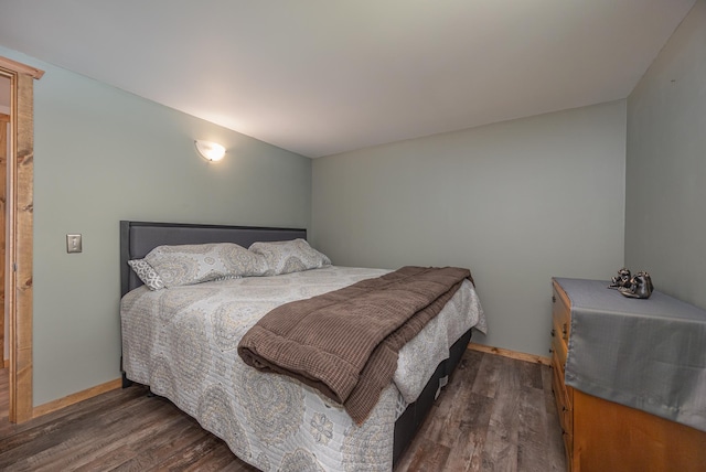 bedroom with dark hardwood / wood-style flooring