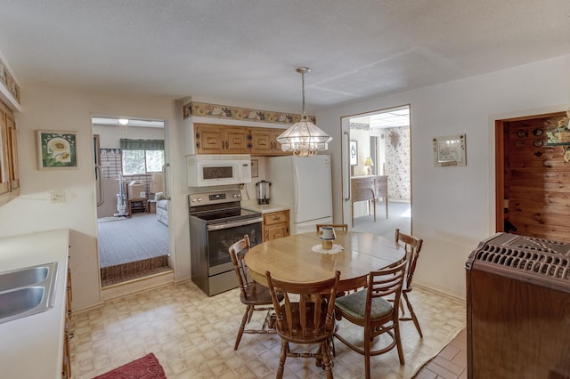 dining room featuring a chandelier, sink, and a textured ceiling