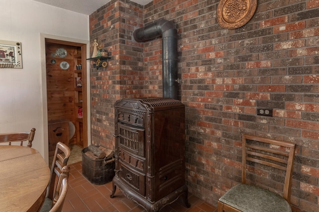 interior space with brick wall and a wood stove