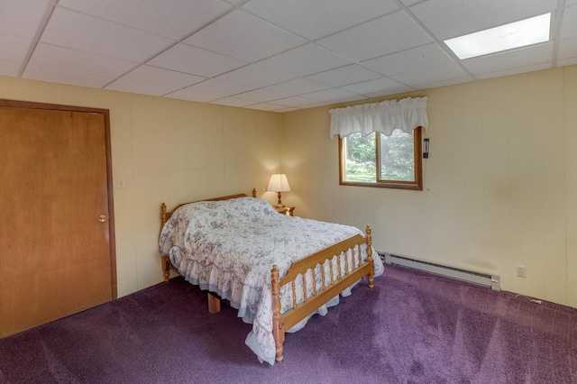 carpeted bedroom featuring a drop ceiling and baseboard heating