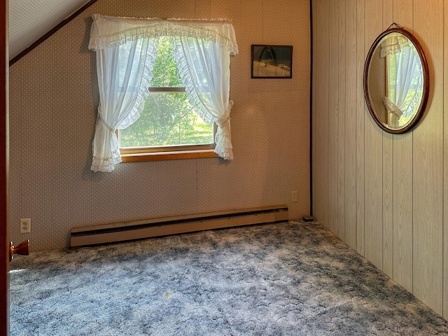 empty room featuring a baseboard heating unit and carpet flooring