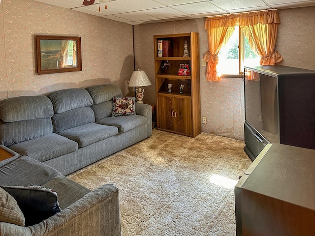 carpeted living room with a drop ceiling and ceiling fan