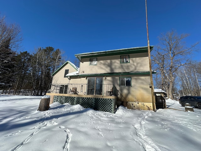 snow covered property with a wooden deck