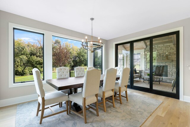 dining room with a healthy amount of sunlight, an inviting chandelier, and light hardwood / wood-style floors