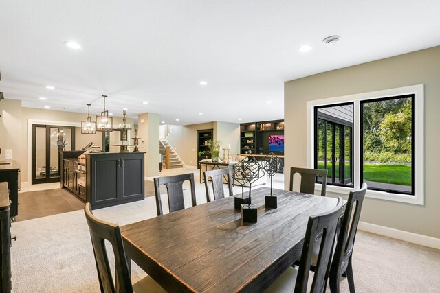 dining area with light colored carpet and an inviting chandelier