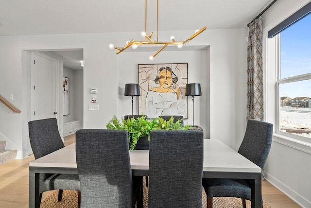 dining area featuring an inviting chandelier and light hardwood / wood-style flooring