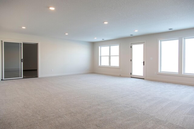 empty room featuring baseboards, recessed lighting, and light colored carpet