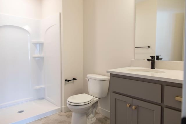 full bathroom with a stall shower, vanity, and toilet