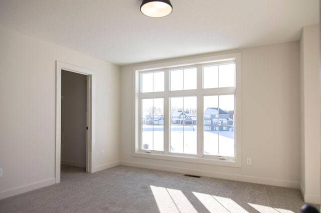 unfurnished room with light carpet, baseboards, and visible vents