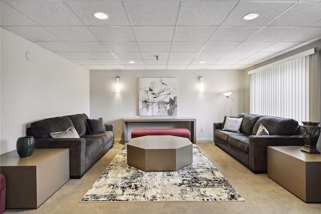 living room with a paneled ceiling and light colored carpet