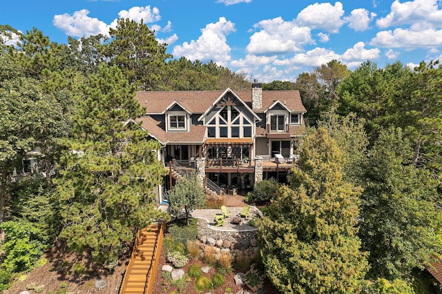 rear view of property featuring a patio area, a sunroom, and a deck