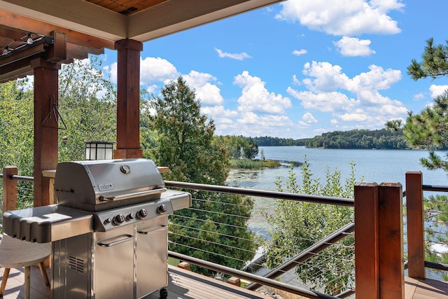 view of patio / terrace with a balcony, a water view, and a grill