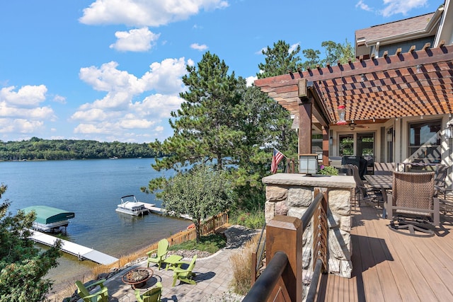 wooden terrace with a pergola, a fire pit, a boat dock, and a water view