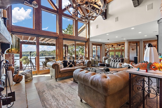 living room with a water view, wood-type flooring, and a notable chandelier