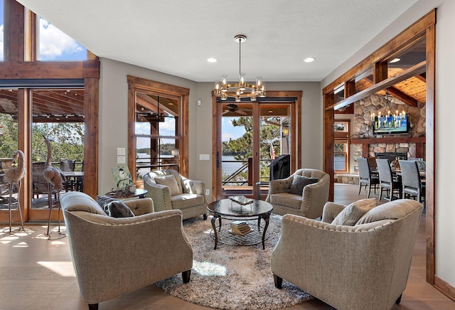 living room featuring light hardwood / wood-style flooring, a textured ceiling, plenty of natural light, and a chandelier