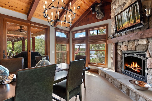 dining space with high vaulted ceiling, a stone fireplace, wooden ceiling, and light wood-type flooring