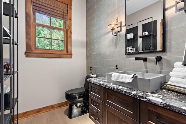 bathroom with tile walls, backsplash, hardwood / wood-style flooring, vanity, and toilet