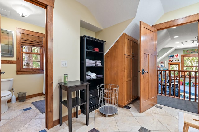 bathroom with lofted ceiling and toilet