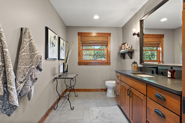 bathroom featuring tile patterned floors, vanity, toilet, and a wealth of natural light