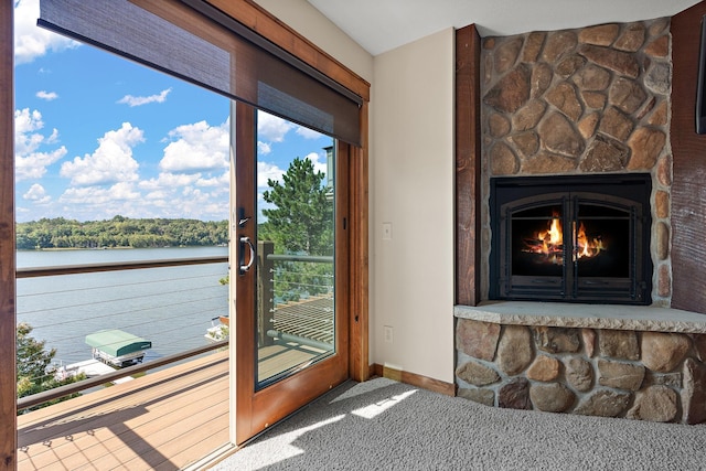 interior space with a water view, a fireplace, and carpet floors