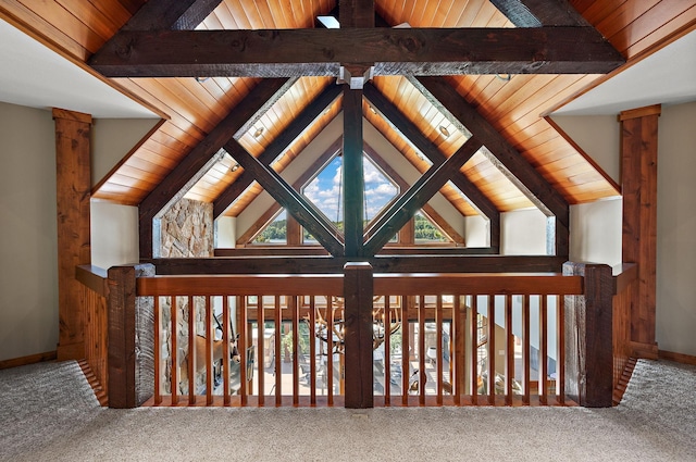 interior space featuring beamed ceiling, wood ceiling, a healthy amount of sunlight, and carpet flooring