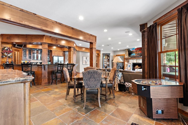 dining room with a stone fireplace