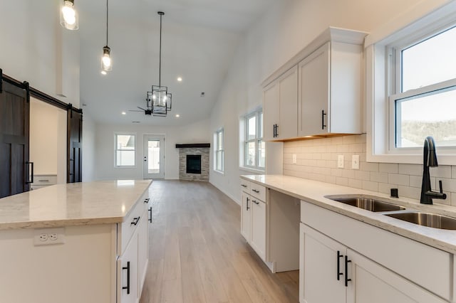 kitchen featuring white cabinets, sink, a kitchen island, and a healthy amount of sunlight