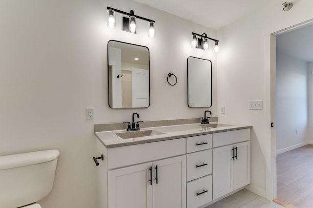 bathroom with hardwood / wood-style floors, vanity, and toilet