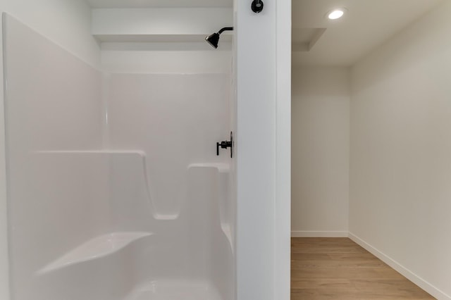 bathroom with a shower and wood-type flooring